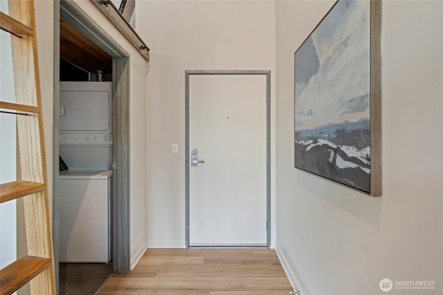 1812 19th Ave Unit 205, Seattle, WA 98122 - washroom featuring stacked washer / drying machine, light wood-type flooring, and baseboards