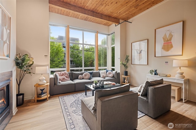 1812 19th Ave Unit 205, Seattle, WA 98122 - living area featuring wooden ceiling with exposed beams, light wood-type flooring, a glass covered fireplace, and baseboards