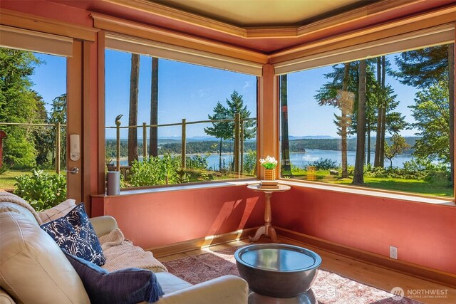 12010 SW Wesleyan Way Unit 1, Vashon, WA 98070 - sunroom / solarium featuring a water view, wood finished floors, baseboards, and ornamental molding