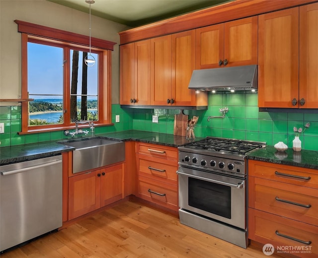 12010 SW Wesleyan Way Unit 1, Vashon, WA 98070 - kitchen with stainless steel appliances, exhaust hood, a sink, tasteful backsplash, and light wood-type flooring