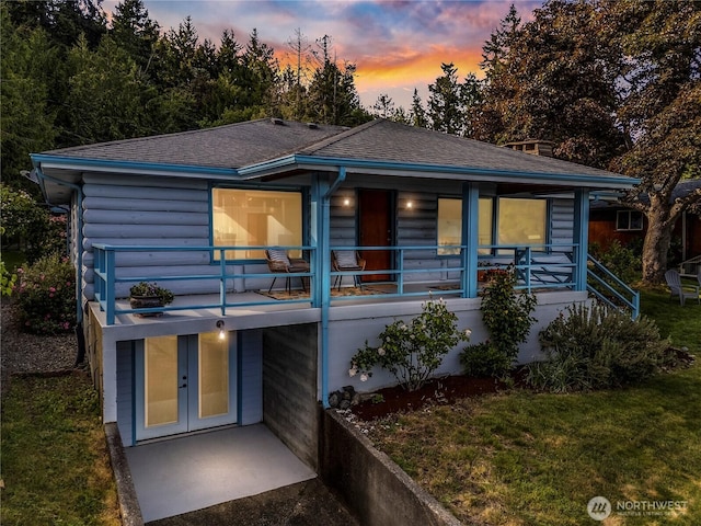 6341 NE Balzow Rd, Suquamish, WA 98392 - back of house at dusk with roof with shingles, a lawn, stairs, and french doors