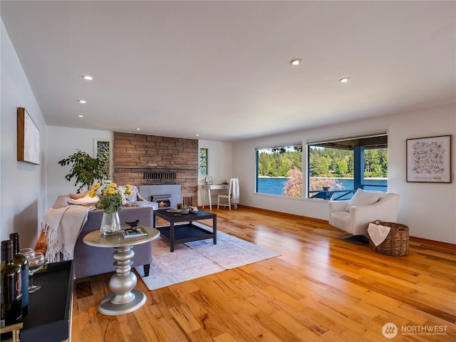 6341 NE Balzow Rd, Suquamish, WA 98392 - living area featuring healthy amount of natural light, wood finished floors, a stone fireplace, recessed lighting, and baseboards