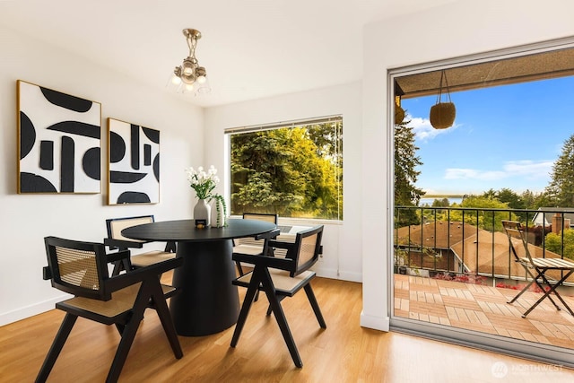 11515 Greenwood Ave N Unit C, Seattle, WA 98133 - dining area featuring a chandelier, light wood-style flooring, and baseboards