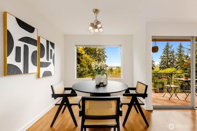 11515 Greenwood Ave N Unit C, Seattle, WA 98133 - dining space featuring a chandelier, healthy amount of natural light, wood finished floors, and baseboards