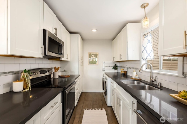 11515 Greenwood Ave N Unit C, Seattle, WA 98133 - kitchen featuring stainless steel appliances, a sink, dark countertops, washer / clothes dryer, and white cabinets