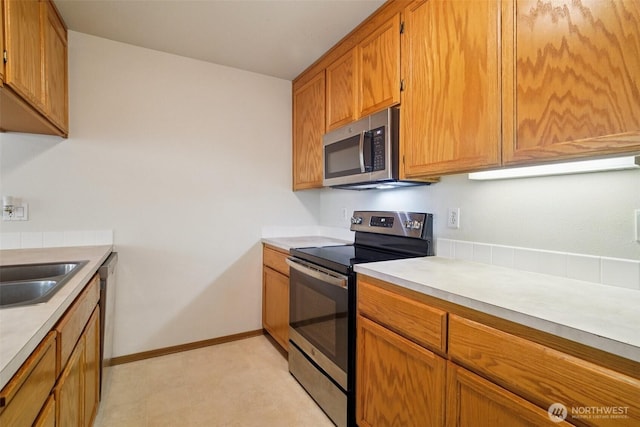 2419 S Meridian Unit B8, Puyallup, WA 98373 - kitchen with appliances with stainless steel finishes, light countertops, and brown cabinetry