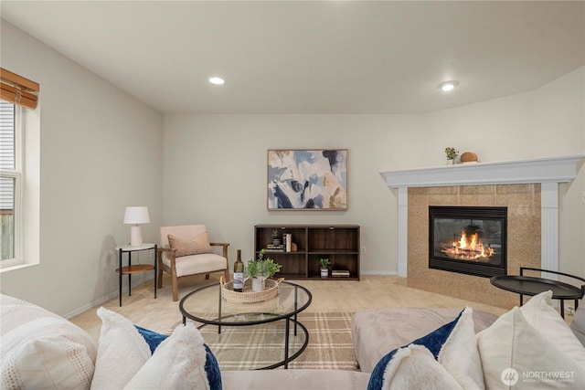 carpeted living area with recessed lighting, a tiled fireplace, and baseboards
