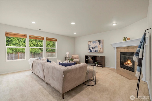 living area with light colored carpet, a tile fireplace, recessed lighting, and baseboards