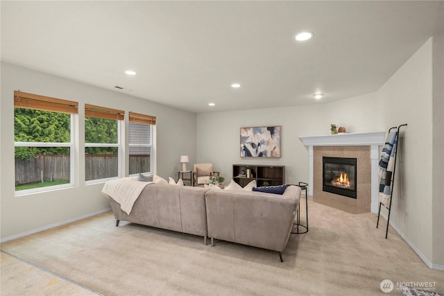 living area with recessed lighting, a tile fireplace, light carpet, and baseboards