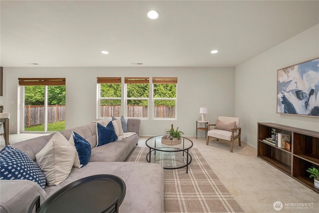 living area with healthy amount of natural light, recessed lighting, light colored carpet, and baseboards