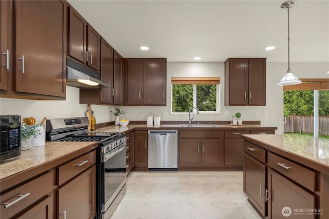 kitchen featuring stainless steel appliances, under cabinet range hood, a sink, decorative light fixtures, and recessed lighting