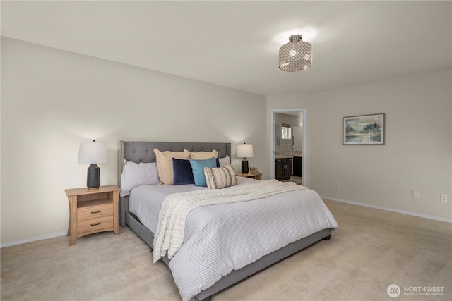 bedroom with light colored carpet, baseboards, and connected bathroom