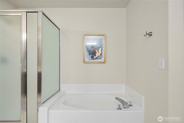bathroom featuring a garden tub and a shower stall