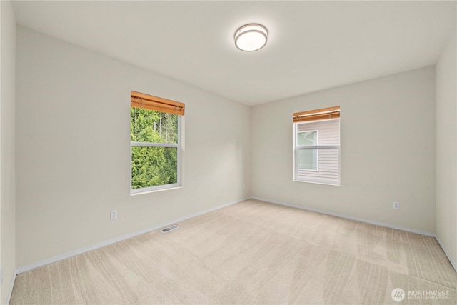carpeted empty room featuring baseboards