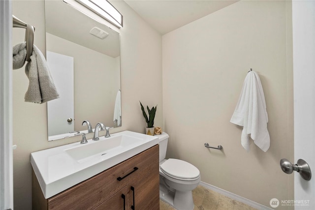 bathroom with toilet, baseboards, and vanity