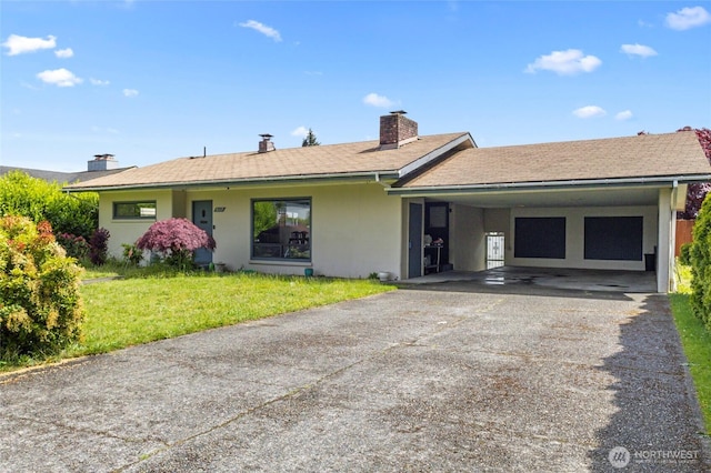 view of front of house featuring asphalt driveway, a carport, a front lawn, a chimney, and stucco siding