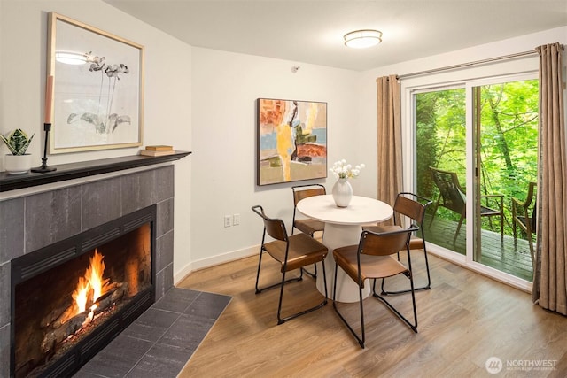 700 Front St S Unit D106, Issaquah, WA 98027 - dining space with a tiled fireplace, light wood-style flooring, and baseboards