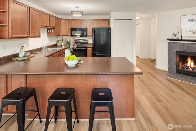 700 Front St S Unit D106, Issaquah, WA 98027 - kitchen featuring black appliances, a peninsula, dark countertops, a sink, and open shelves