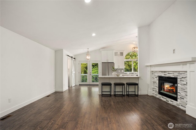 1420 Mitchell Rd, Lake Stevens, WA 98258 - living area with dark wood-style floors, lofted ceiling, baseboards, a barn door, and a tile fireplace