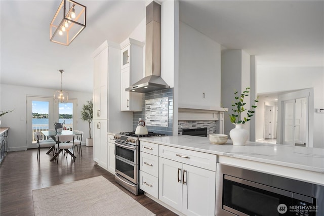 1420 Mitchell Rd, Lake Stevens, WA 98258 - kitchen with appliances with stainless steel finishes, wall chimney range hood, tasteful backsplash, white cabinets, and pendant lighting