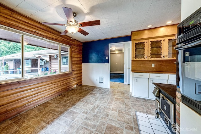 833 S Point Rd, Port Ludlow, WA 98365 - kitchen with black oven, a ceiling fan, dark countertops, light stone finish floors, and glass insert cabinets