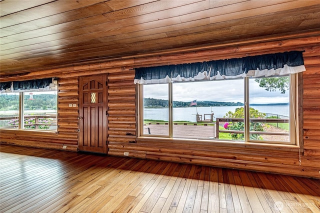 833 S Point Rd, Port Ludlow, WA 98365 - unfurnished living room featuring wooden ceiling, wood-type flooring, and a water view