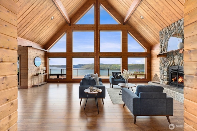 790 N Hamma Ridge Dr, Lilliwaup, WA 98555 - living room with high vaulted ceiling, a fireplace, wooden ceiling with exposed beams, wood walls, and hardwood / wood-style flooring