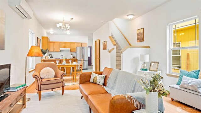 6508 NE Plum St, Suquamish, WA 98392 - living area with an AC wall unit, a chandelier, and light wood finished floors