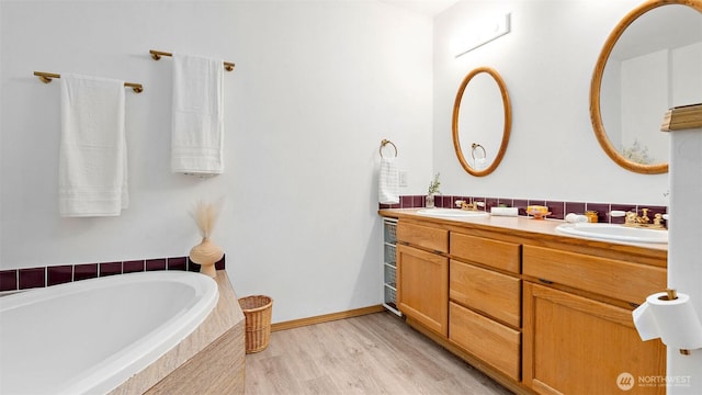 6508 NE Plum St, Suquamish, WA 98392 - bathroom with double vanity, tiled bath, and wood finished floors