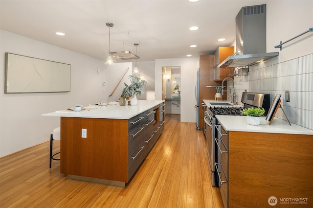 1833 27th Ave, Seattle, WA 98122 - kitchen with island exhaust hood, stainless steel range with gas cooktop, a sink, brown cabinets, and recessed lighting