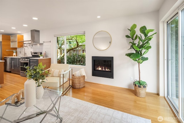 1833 27th Ave, Seattle, WA 98122 - living room featuring plenty of natural light, light wood-type flooring, a glass covered fireplace, and recessed lighting