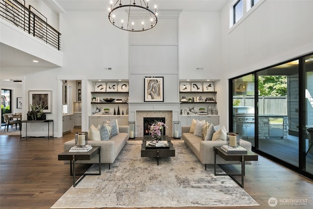 27 Tulalip Ky, Bellevue, WA 98006 - living area featuring dark wood-style floors, a warm lit fireplace, a high ceiling, and a chandelier
