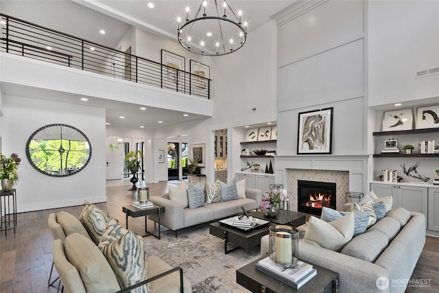27 Tulalip Ky, Bellevue, WA 98006 - living room with wood finished floors, a tiled fireplace, a chandelier, a high ceiling, and recessed lighting