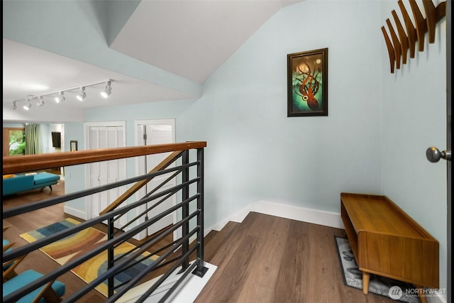 1524 NE 140th Unit D2, Seattle, WA 98125 - staircase with wood finished floors, vaulted ceiling, rail lighting, and baseboards