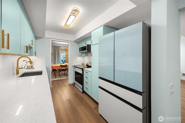 1524 NE 140th Unit D2, Seattle, WA 98125 - kitchen with electric range, stainless steel microwave, fridge, a sink, and decorative backsplash