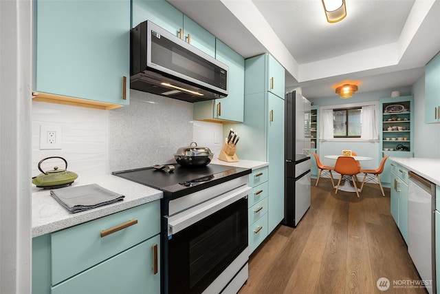 1524 NE 140th Unit D2, Seattle, WA 98125 - kitchen featuring appliances with stainless steel finishes, light countertops, dark wood-type flooring, and decorative backsplash