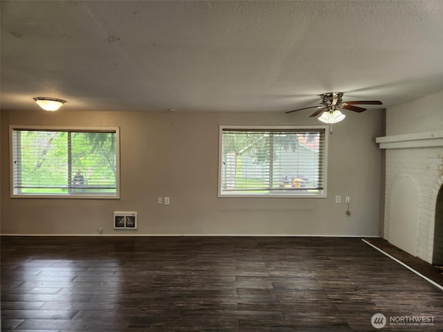 12597 US Highway 12, Randle, WA 98377 - empty room featuring heating unit, healthy amount of natural light, ceiling fan, dark wood-type flooring, and a textured ceiling