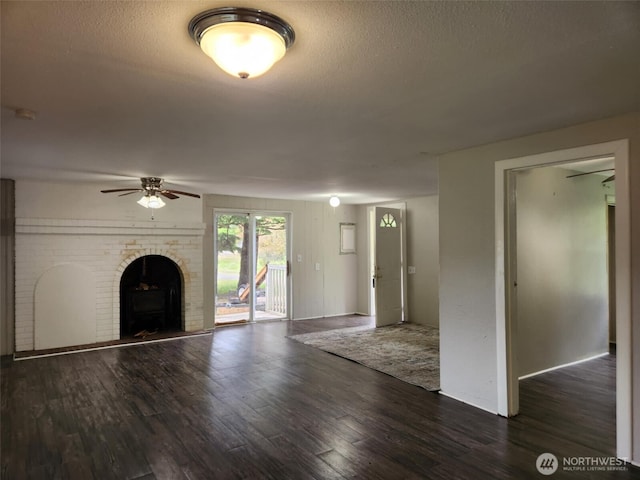 12597 US Highway 12, Randle, WA 98377 - unfurnished living room featuring wood finished floors, ceiling fan, a wood stove, and a textured ceiling