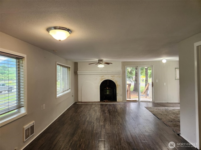 12597 US Highway 12, Randle, WA 98377 - unfurnished living room featuring dark wood-style flooring, a ceiling fan, plenty of natural light, and a textured ceiling