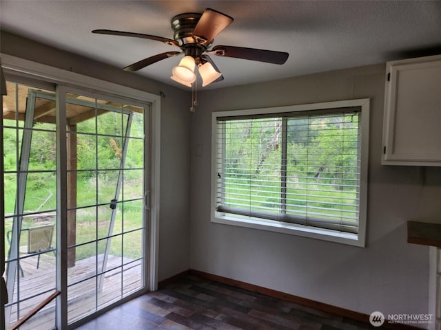 12597 US Highway 12, Randle, WA 98377 - unfurnished dining area with baseboards, ceiling fan, and dark wood-style flooring