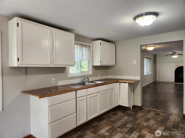 12597 US Highway 12, Randle, WA 98377 - kitchen featuring a sink, white cabinetry, dark wood finished floors, a fireplace, and ceiling fan
