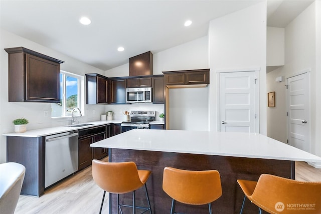 1413 Alder Ln, Gold Bar, WA 98251 - kitchen featuring appliances with stainless steel finishes, a sink, lofted ceiling, dark brown cabinetry, and light wood-style flooring
