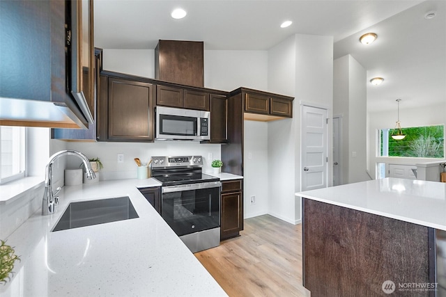 1413 Alder Ln, Gold Bar, WA 98251 - kitchen with stainless steel appliances, a sink, dark brown cabinets, light wood-style flooring, and pendant lighting