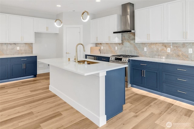 21411 39th Dr SE Unit A, Bothell, WA 98021 - kitchen with wall chimney range hood, stainless steel range with gas stovetop, blue cabinets, a sink, and recessed lighting