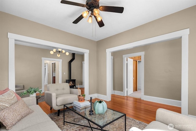 2404 Old Lakeway Dr, Bellingham, WA 98229 - living room with a wood stove, light wood finished floors, ceiling fan, and baseboards