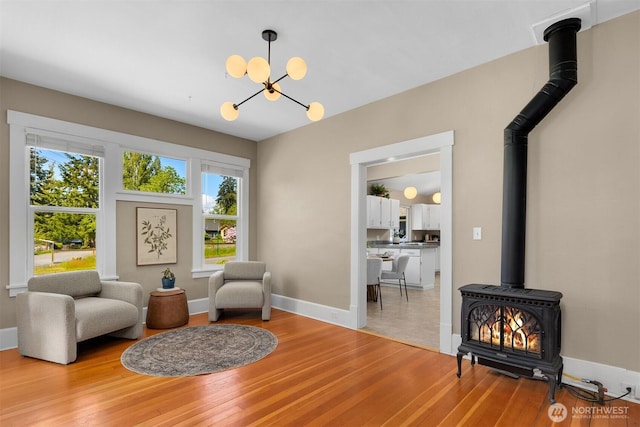 2404 Old Lakeway Dr, Bellingham, WA 98229 - sitting room featuring a wood stove, light wood finished floors, a chandelier, and baseboards