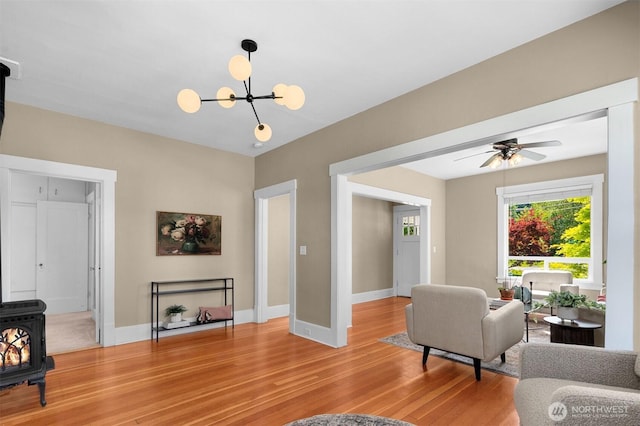 2404 Old Lakeway Dr, Bellingham, WA 98229 - living area with a wood stove, light wood-type flooring, a chandelier, and baseboards