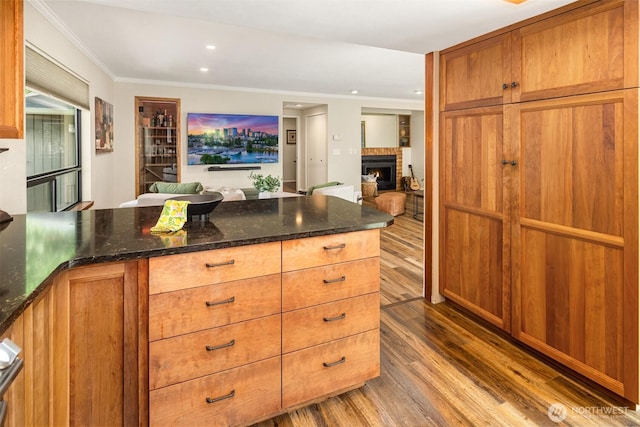 3716 Lake Washington Blvd SE Unit C, Bellevue, WA 98006 - kitchen featuring wood finished floors, a brick fireplace, open floor plan, dark stone counters, and crown molding