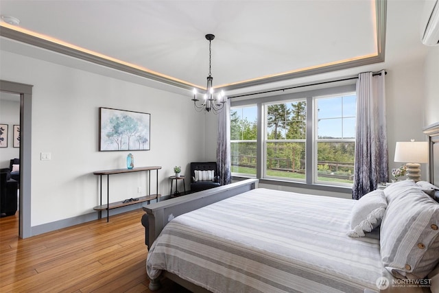 321 W Berry Ridge Rd, Shelton, WA 98584 - bedroom with wood finished floors, a chandelier, a wall unit AC, baseboards, and a tray ceiling