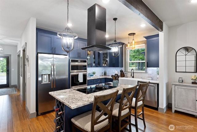 321 W Berry Ridge Rd, Shelton, WA 98584 - kitchen featuring appliances with stainless steel finishes, island exhaust hood, a chandelier, blue cabinets, and backsplash